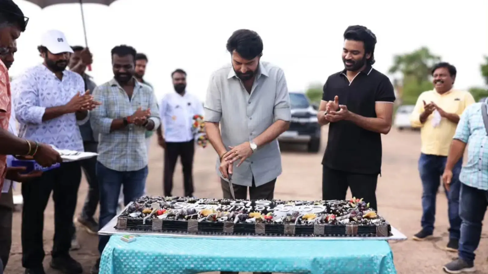 Dhanush and ‘Om’ Crew Cut Cake to Celebrate Mammootty’s Padma Bhushan